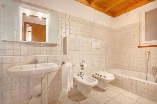 een badkamer met een wastafel, een toilet en een bad bij Villa Chiara APT 2-Appartamento in villa con piscina in Cavaion Veronese