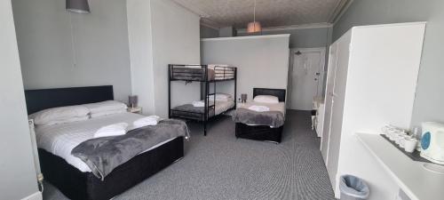 a bedroom with two beds and a shelf in it at Royal Pier in Sandown