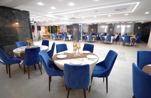 Formercity Termal Hotel في إسكي شهير: غرفة طعام مع طاولات وكراسي زرقاء