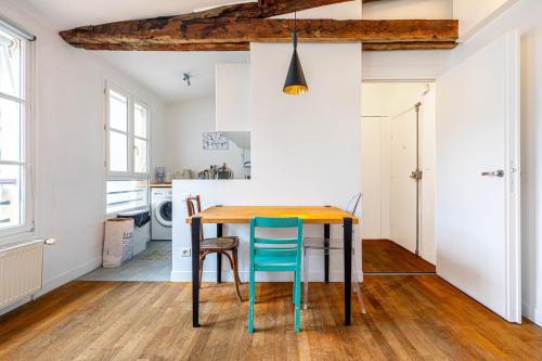 une cuisine et une salle à manger avec une table et des chaises en bois dans l'établissement GuestReady - City center gem near attractions, à Paris