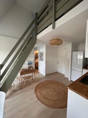 un salon avec un escalier et une table dans l'établissement L'Appart 502, appartement familial et sa vue mer., à Villers-sur-Mer