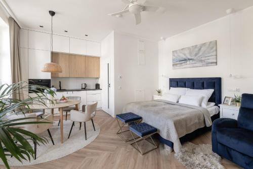 Cet appartement comprend une chambre avec un lit et une table ainsi qu'une cuisine. dans l'établissement Sanhaus Apartments - Apartamenty Koral z parkingiem - 200 m od plaży, à Sopot