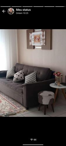 sala de estar con sofá y mesa en Clenilda, en Praia Grande
