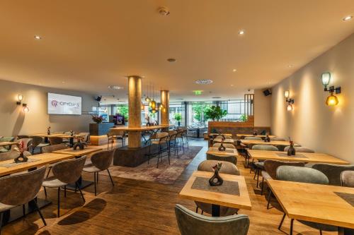 a restaurant with wooden tables and chairs at CityClass Hotel am Dom in Cologne