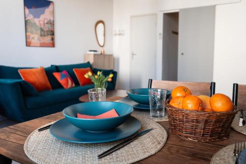 a dining room table with blue bowls and oranges on it at Orange Sunset in Draguignan