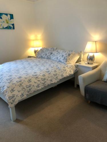 a bedroom with a bed and a chair and two lamps at Puffin. Comfortable Annexe Central Falmouth in Falmouth