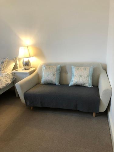 a couch in a room with a bed and a lamp at Puffin. Comfortable Annexe Central Falmouth in Falmouth