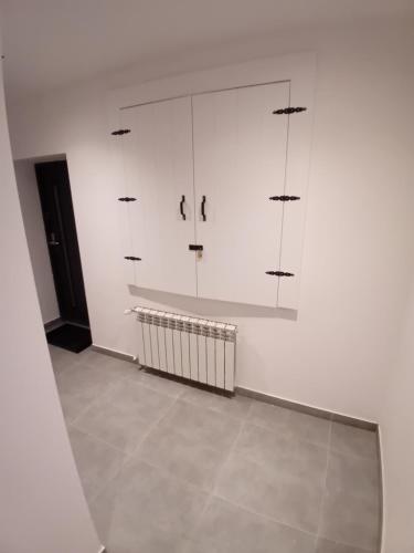 a room with white cabinets and a tile floor at Viva Apartments in Oświęcim