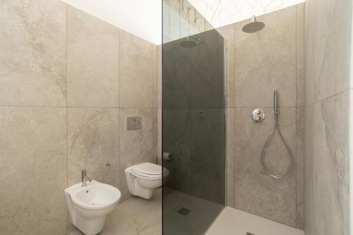 a bathroom with a shower with a toilet and a sink at Vicoloterzo Suite in Bari