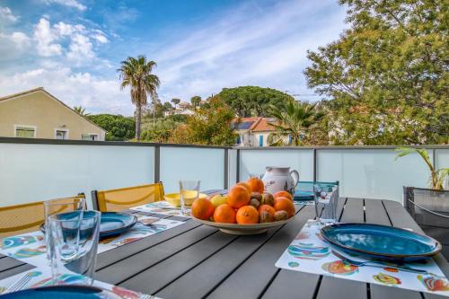 une table avec un bol de fruits sur un balcon dans l'établissement Nouvelle Ère - Appt à moins d’un km de la plage, au Lavandou