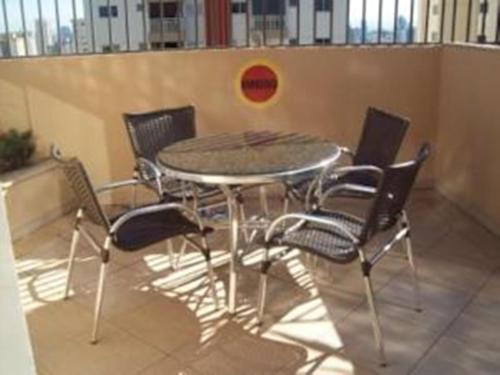 einen Tisch und Stühle in einem Zimmer mit einer Wand in der Unterkunft Flats Sierra Bela Vista in Goiânia