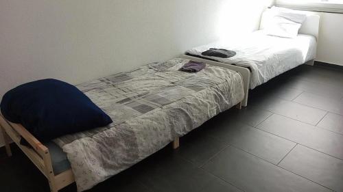 um pequeno quarto com uma cama e uma cadeira em Viva Zimmer in Heilbronn Zentrum em Heilbronn