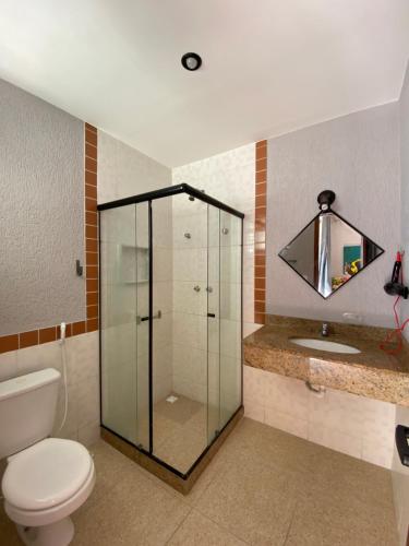a bathroom with a shower and a toilet and a sink at Varandas ao mar loft 302 Praia Grande in Arraial do Cabo