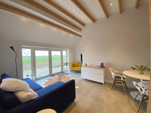 a living room with a blue couch and a table at HollyWad in Holwerd