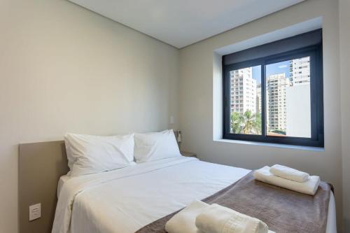 Schlafzimmer mit einem Bett mit weißer Bettwäsche und einem Fenster in der Unterkunft BHomy Perdizes - Uma quadra do Allianz Pq VA403 in São Paulo