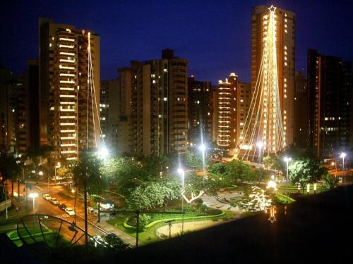 eine nachts beleuchtete Stadt mit hohen Gebäuden in der Unterkunft Flats Sierra Bela Vista in Goiânia