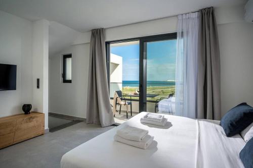 a bedroom with a bed and a view of the ocean at Destino Grand Villa Private Pool in Gournes