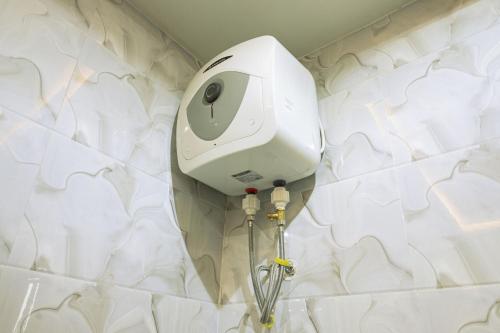 um chuveiro branco na casa de banho com azulejos brancos em CMP APARTMENTS em Kasoa