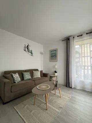 un salon avec un canapé et une table dans l'établissement Appartement à 300 m de la mer, à Cabourg