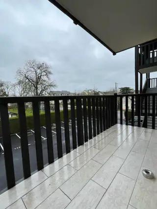 un balcon vide avec vue sur une rue dans l'établissement Appartement à 300 m de la mer, à Cabourg