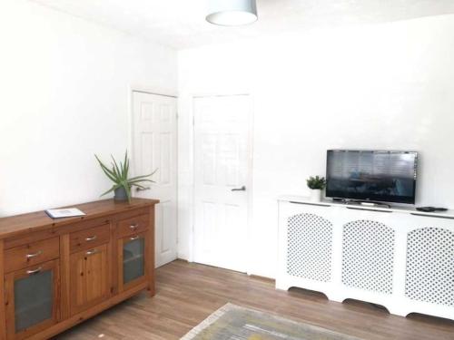 een woonkamer met een televisie aan een witte muur bij Two bedroom terrace house with parking in Hull