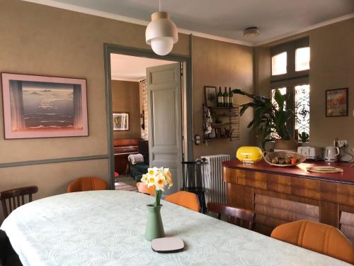 une salle à manger avec une table et un vase de fleurs. dans l'établissement Maison familiale éco rénovée, à Ault