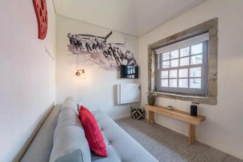 uma sala de estar com um sofá e uma janela em GuestReady - Genuine Oporto Apts - 4 no Porto