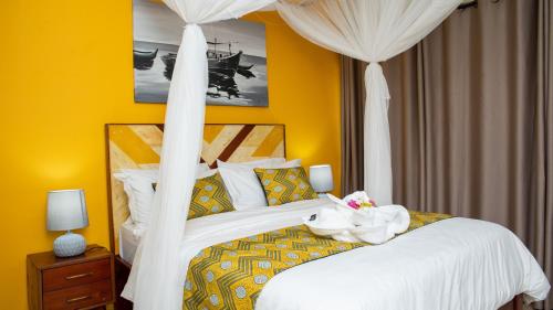 a bedroom with a white bed with a canopy at Kaweta Cottage in Nkhata Bay