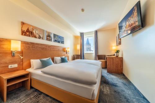 a hotel room with a large bed and a couch at CityClass Hotel am Dom in Cologne