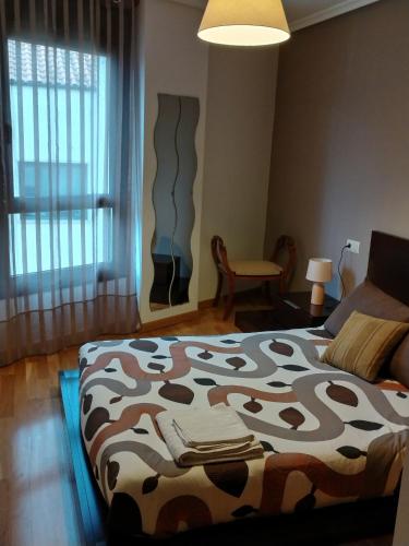 a bedroom with a bed with a cow blanket on it at Apartamento Casa Lomberte in Allariz