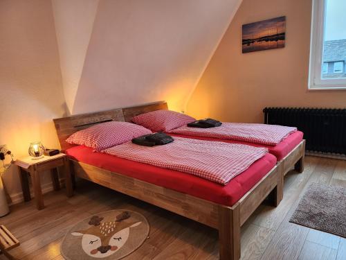 a bedroom with two twin beds with red sheets at Eifelblümchen in Heimbach