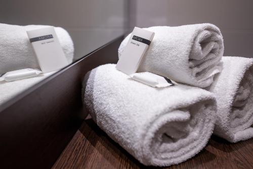 two stacks of towels in a hotel room at Hampshire Hotel - Delft Centre in Delft