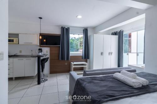 a bedroom with a bed and a kitchen with a counter at SPT - Studios Convenientes em Blumenau/SC in Blumenau