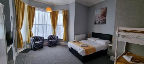 a hotel room with a bed and two chairs at Royal Pier in Sandown