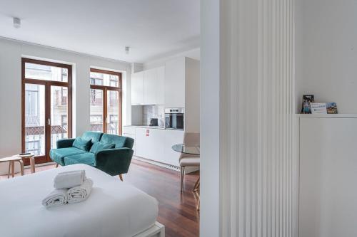 a living room with a blue couch and a kitchen at GuestReady - Almada 516 in Porto