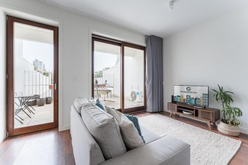a living room with a couch and a tv at GuestReady - Almada 516 in Porto