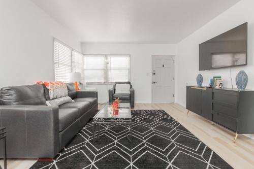 a living room with a grey couch and a black rug at Cool and Cozy Pad Close to Everything in Los Angeles