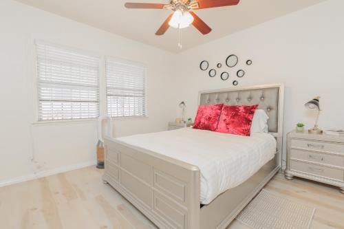 a bedroom with a large white bed with red pillows at Cool and Cozy Pad Close to Everything in Los Angeles