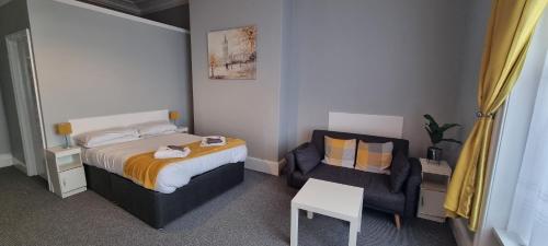 a small bedroom with a bed and a chair at Royal Pier in Sandown