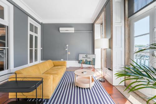 a living room with a yellow couch and a blue rug at GuestReady - Innvict Residences in Porto
