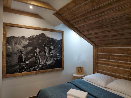 a bedroom with a painting on the wall at Apartamenty Bachledzki Wierch in Zakopane