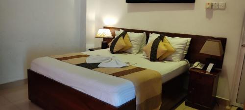 a bedroom with a large bed with towels on it at Empire Valley Hotel in Kandy