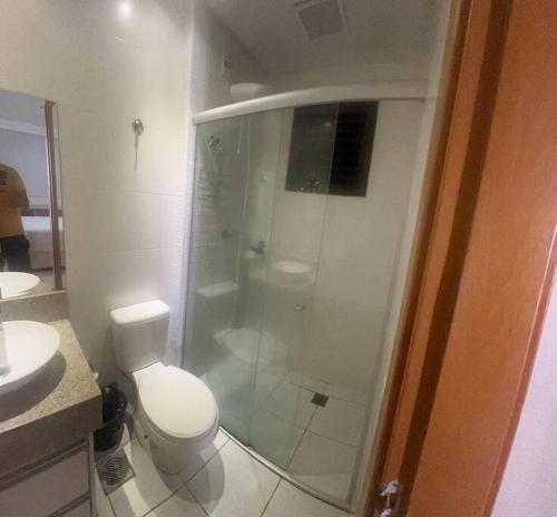 een badkamer met een toilet en een glazen douche bij Flat espetacular Flamboyant 2 in Goiânia