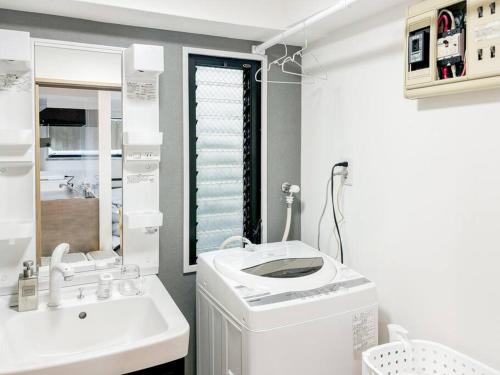 een badkamer met een wasmachine en een wastafel bij ゲストルーム上野桜木(上野駅and日暮里駅) in Tokyo