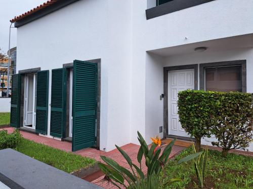 a white house with green shutters on it at Wild Blue By SVL in Ponta Delgada