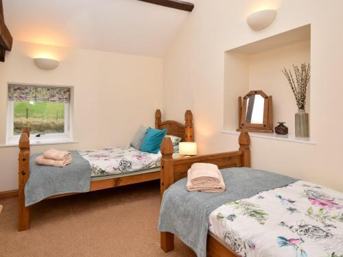a bedroom with two beds and a mirror at 2 bed property in Whitton Northumberland 61267 in Rothbury
