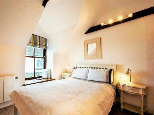 um quarto com uma grande cama branca e uma janela em 3 Bed in Mousehole 81271 em Mousehole