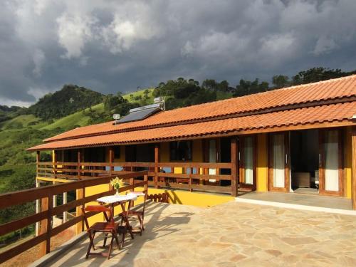 un edificio con tavolo e sedie su un patio di Sitio Por do Sol - Hospedagem a Delfim Moreira