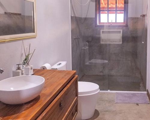 e bagno con lavandino, servizi igienici e doccia. di Sitio Por do Sol - Hospedagem a Delfim Moreira