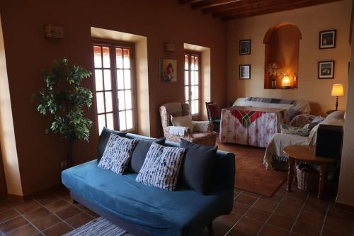 een woonkamer met een blauwe bank en een slaapkamer bij Preciosa casa en Carratraca in Carratraca